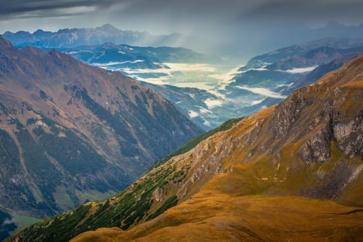 Hohe Tauern mountains and lake from above Grossglockner road at dramatic dawn, Austria