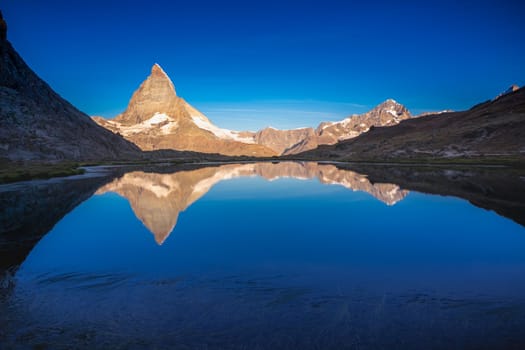 Reflection of the Matterhorn on blue and placid lake at sunrise, Swiss Alps, Zermatt, Switzerland