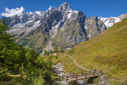Idyllic alpine landscape of Aosta valley near Mont Blanc massif with river and bridge, Italy