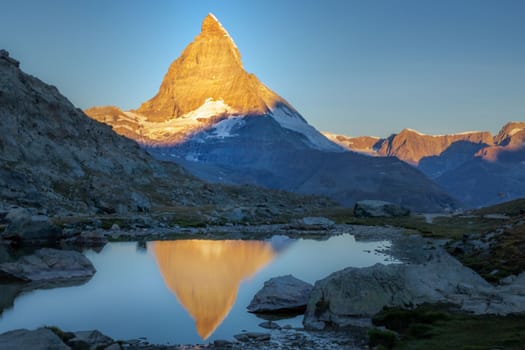 Reflection of the Matterhorn on blue and placid lake at sunrise, Swiss Alps, Zermatt, Switzerland