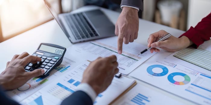 Team of business investment consultant analyzing company annual financial report working with documents pie and donut chart, using laptop, Business and Financial concept.