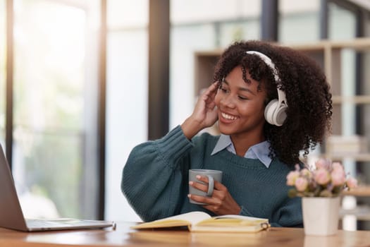 Young black African woman wear headphone and enjoy with music via music app on mobile phone