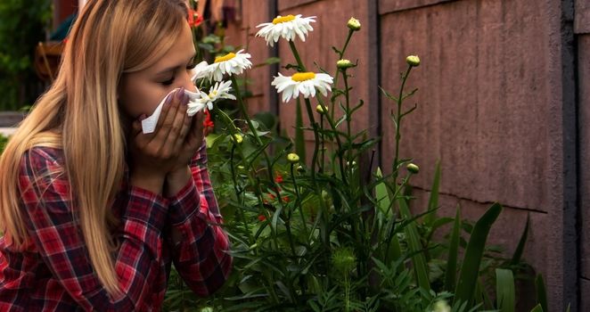 A young woman is allergic to flowers. Selective focus