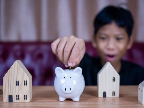 Boy saving money in a white pig piggy bank.Saving concept. Saving for the future.