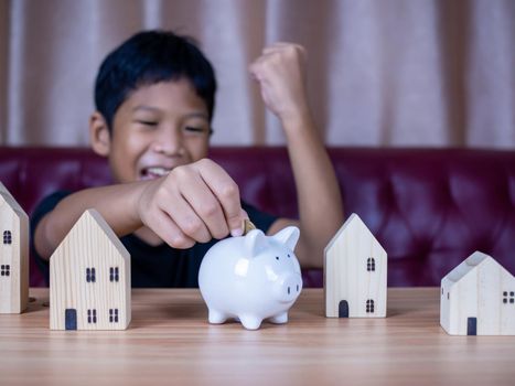 Boy saving money in a white pig piggy bank.Saving concept. Saving for the future.