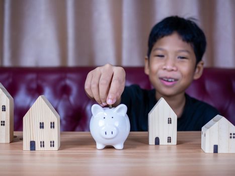 Boy saving money in a white pig piggy bank.Saving concept. Saving for the future.