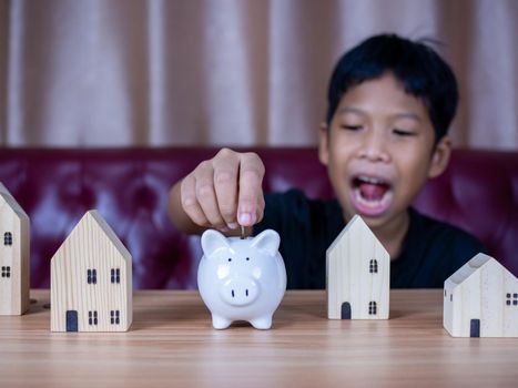 Boy saving money in a white pig piggy bank.Saving concept. Saving for the future.