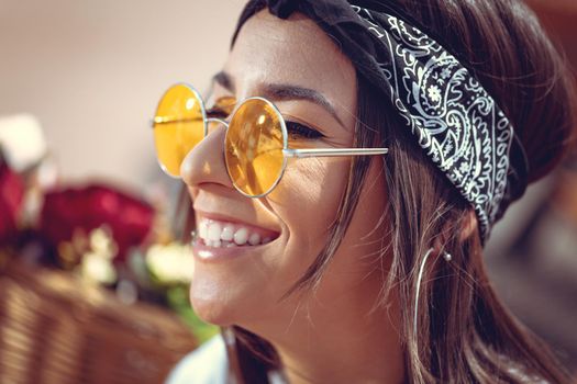 Portrait of a happy smiling young woman with sunglasses who is enjoying in a summer sunny day.