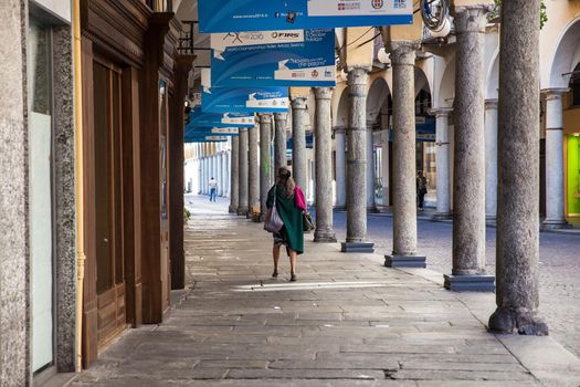 NOVARA, ITALY - OCTOBER, 05: Old lady walking under the the typical arcade in Novara on October 05, 2016