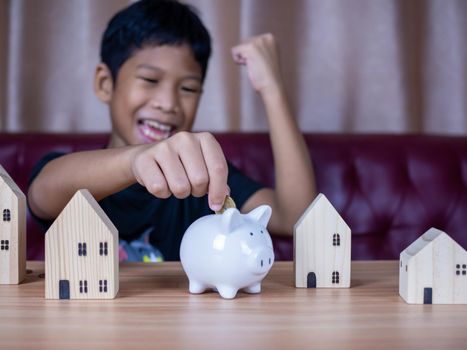 Boy saving money in a white pig piggy bank.Saving concept. Saving for the future.