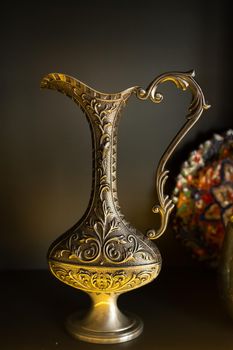 Old copper jug from the east on a black background.