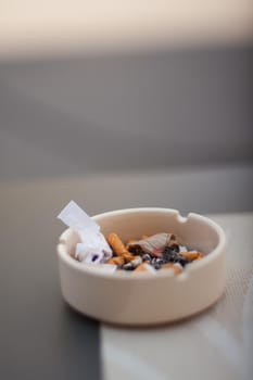 View of burned cigarette in ashtray on table