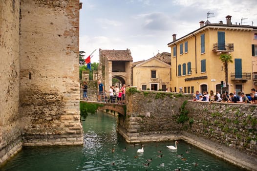 Sirmione, Italy-October 9, 2018: People relax in the town of Sirmione near the castle of Scaligera.