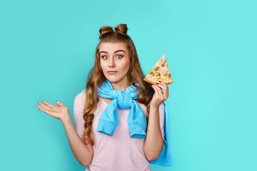 cheerful young woman holding delicious pizza slice while looking at the camera, throwing up his hands to the sides