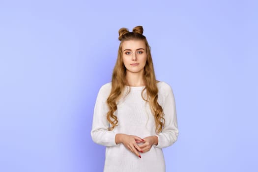 curly brunette woman in sweater isolated on pastel violet background