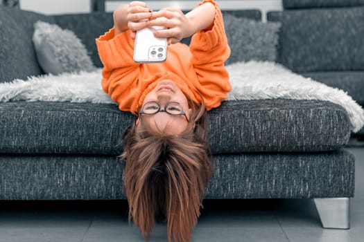 child with smartphone on sofa, home online education. High quality photo