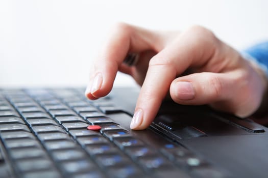 The girl is working on a laptop. Freelance, remote work. Close-up of a hand on a keyboard