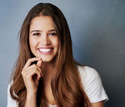 Its plain confidence. Studio shot of an attractive young woman posing against a gray background