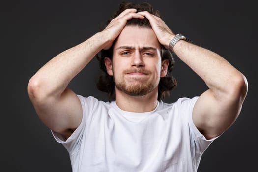 shocked man with surprise expression, fear and excited face on dark gray studio background