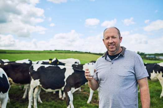 The best cows make the best milk. Cropped portrait of a male farmer standing with a glass of milk on his dairy farm