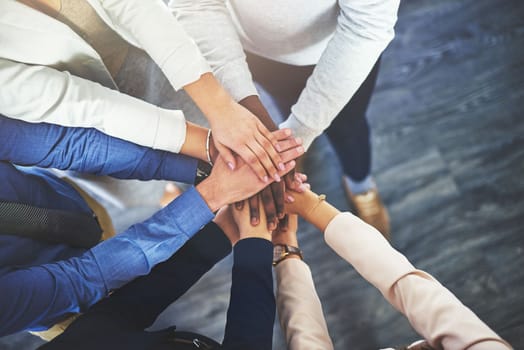 The secret is always teamwork. a group of businesspeople putting their hands together in a huddle