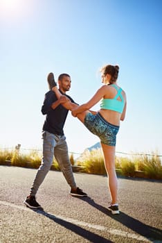 Supporting each other in the pursuit of a healthier lifestyle. a sporty young couple stretching before a run outside