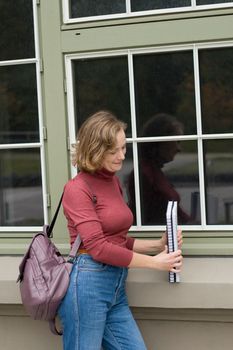 young caucasian girl going back to college, standing with a backpack and notebooks and smiling, back to school, High quality photo