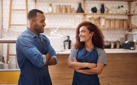 Whats next on the business plan. two young business owners standing in their cafe with their arms folded while looking at each other