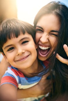 My mom is the best. Closeup portrait of an attractive young woman and her young son outside