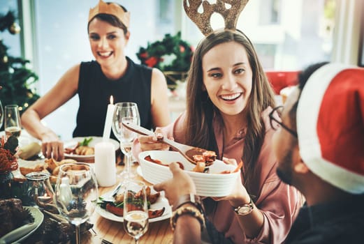 Youve seriously never tried this before. a group of cheerful young friends having Christmas lunch together at home