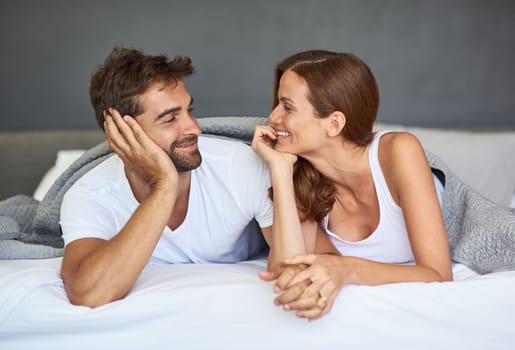 Lets have a lazy day today. a happy young couple relaxing in bed together at home