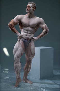 Studio shot of a muscular man. Adult bodybuider without clothes put his hands on his hips and looks to the side. Professional male modeling posing concept