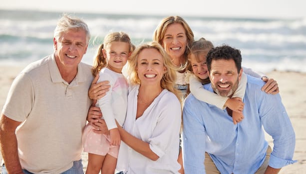 Portrait of a senior caucasian couple at the beach with their children and grandchildren. Caucasian family relaxing on the beach having fun and bonding.