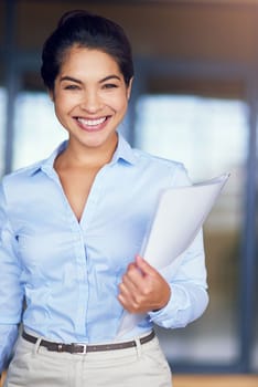 She always brings her A-game to work. Cropped portrait of a young businesswoman holding paperwork