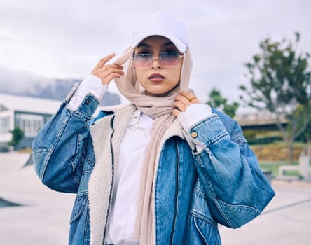 Beautiful young arab woman posing outdoors in a headscarf. Attractive female muslim wearing a hijab posing outside. Shes all about style and fashion. Mixed race woman looking confident and trendy.