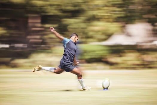 One mixed race rugby player kicking off during a rugby match outside on the field. Hispanic man taking a penalty or attempting to score a conversion during a game. Hes the kicker on the team.