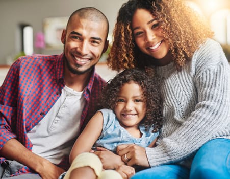 Family puts the happy into a home. Portrait of a happy young family of three spending quality time together at home