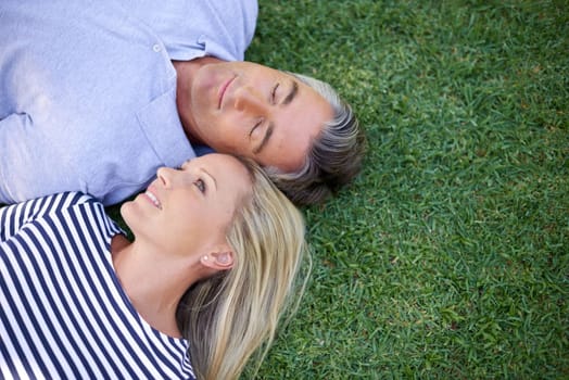 Their love comes naturally. High angle shot of a mature couple lying in the park