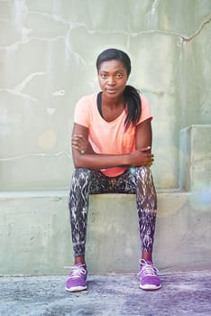 Focused on fitness. Portrait of an attractive and sporty young woman sitting outdoors