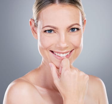 Stand out from the crowd. Studio portrait of an attractive mature woman touching her face against a grey background