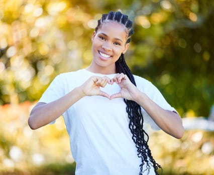 Show your support. Closeup shot of a beautiful young woman forming a heart shape while standing outside