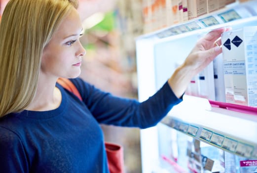 Shes a savvy shopper. a young woman browsing the shelves in a pharmacy