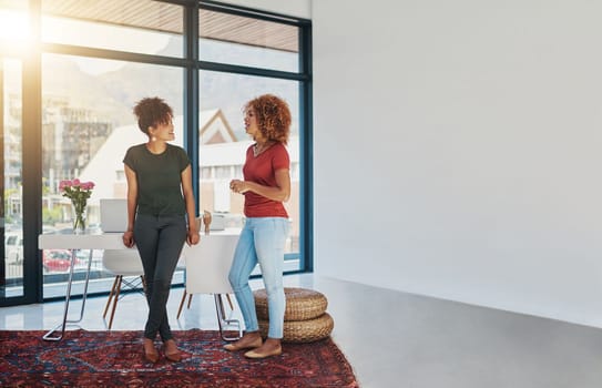 Collaborate with people you can learn from. two businesswomen chatting in an office