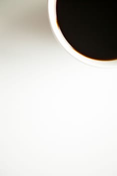 Over top view of coffee cup on white surface