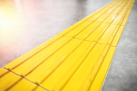 Walkway or yellow tactile tiles for the blind close up.
