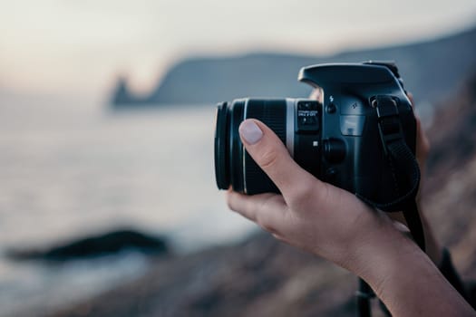 Woman travel sea. Happy tourist taking picture outdoors for memories. Woman traveler looks at the edge of the cliff on the sea bay of mountains, sharing travel adventure journey.