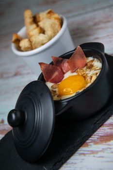 Recipe Oeuf cocotte with fresh cream sauce, Roquefort and walnuts, ham chips, toasted bread sticks. High quality photo
