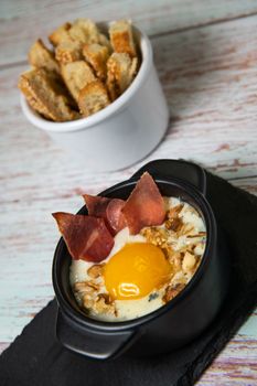 Recipe Oeuf cocotte with fresh cream sauce, Roquefort and walnuts, ham chips, toasted bread sticks. High quality photo