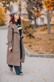 A woman walks outdoors in autumn, enjoys the autumn weather