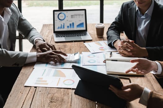 Business People Meeting using laptop computer, calculator, stock market chart paper for analysis planning to improve quality next month. Conference Discussion Corporate Concept.